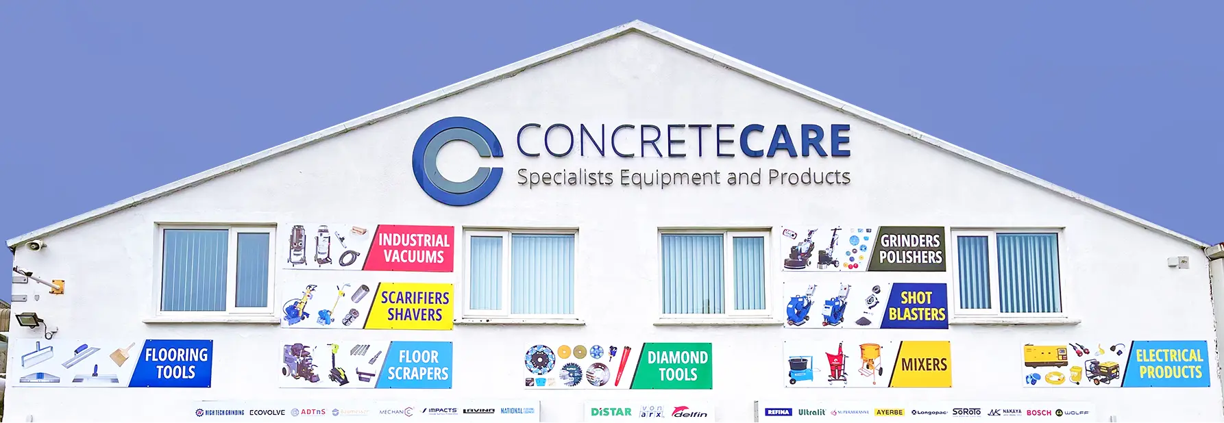 The Concrete Care premises: a white gable wall with the company sign and painted department panels for industrial vacuums, scarifiers, floor scrapers, diamond tools, grinders and polishers, shot blasters, mixers and electrical products